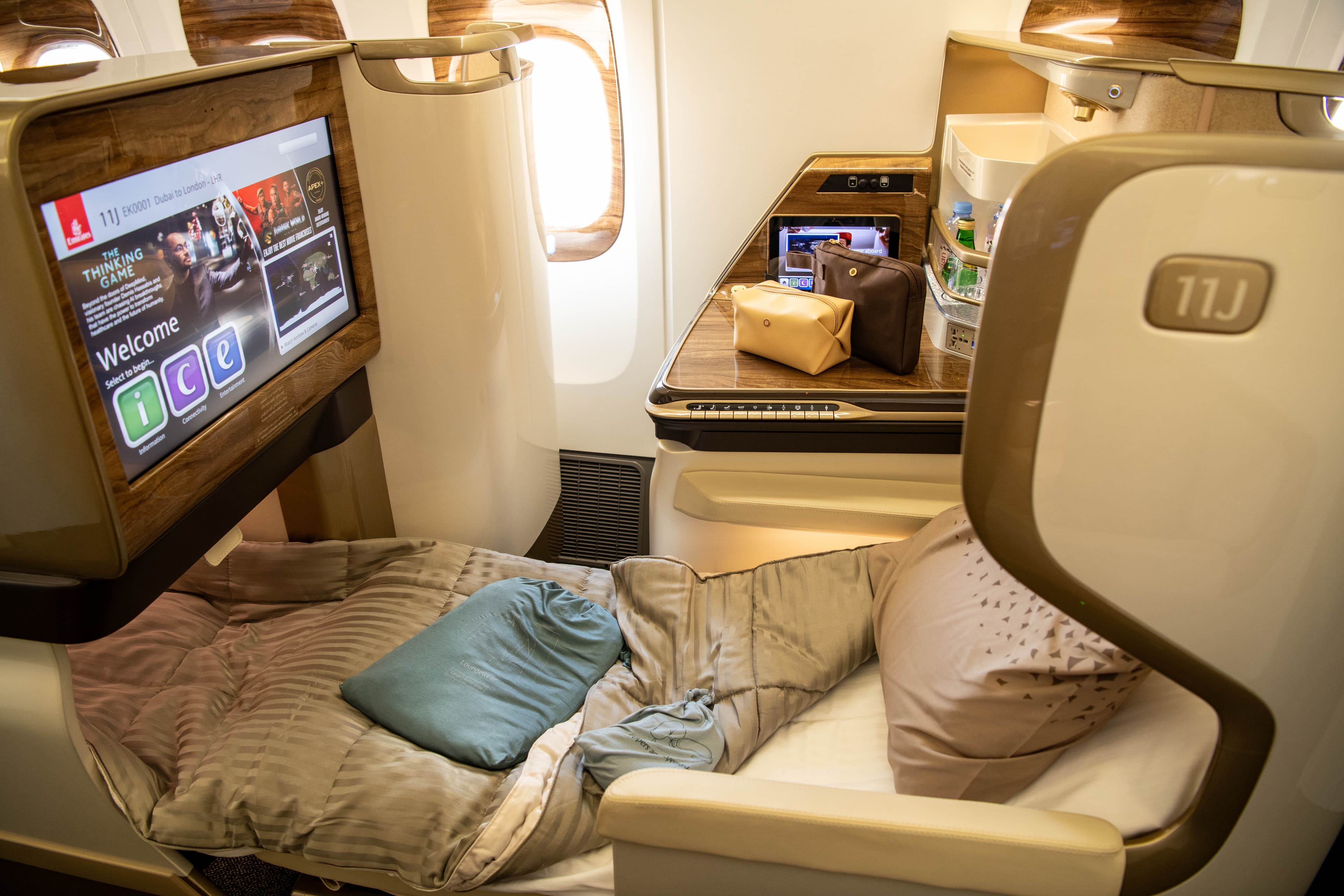 Emirates Business Class lie-flat seat with premium bedding and ICE entertainment on Dubai to London flight
