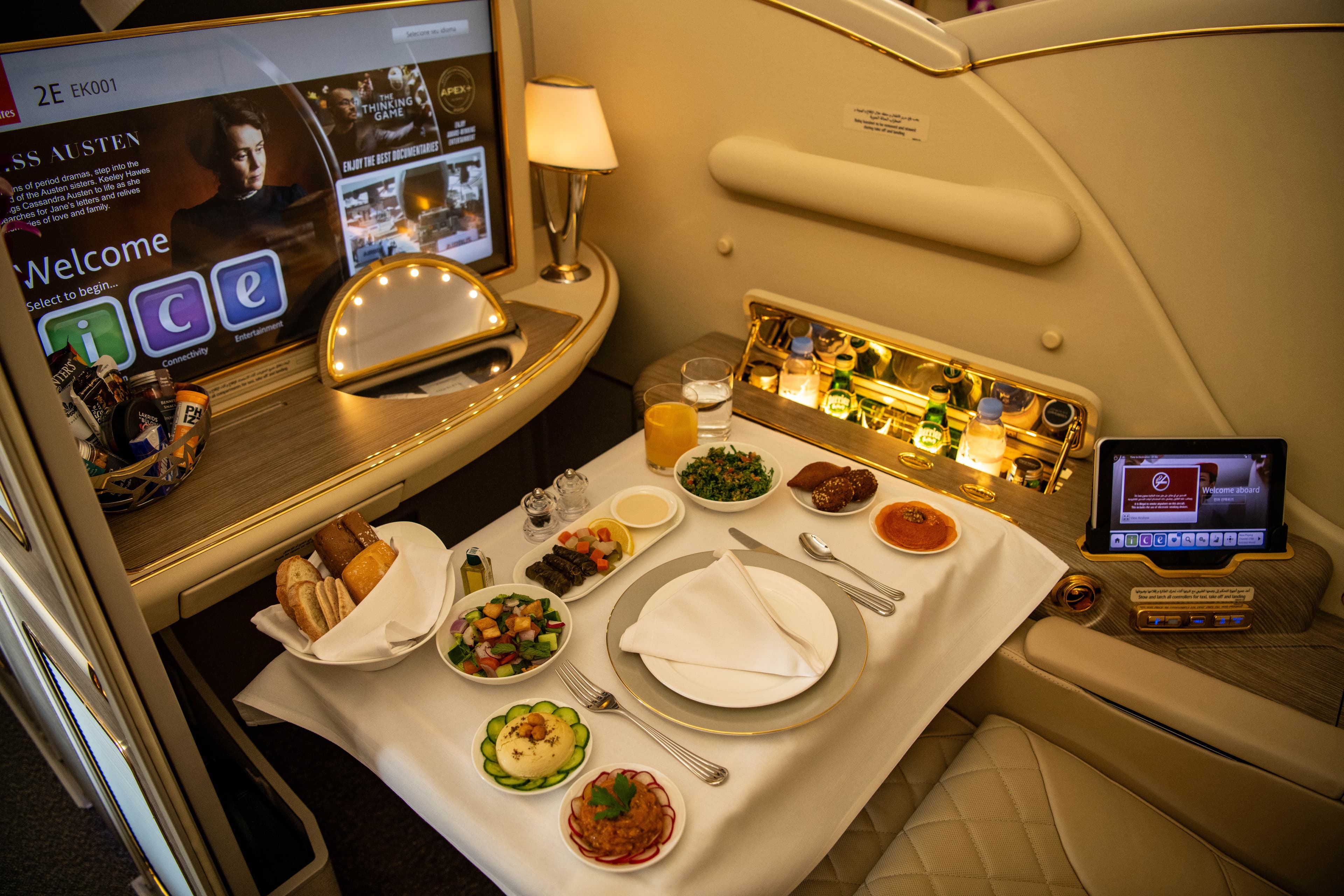 Emirates A380 First Class private suite with gourmet inflight dining — luxury travel experience above the clouds