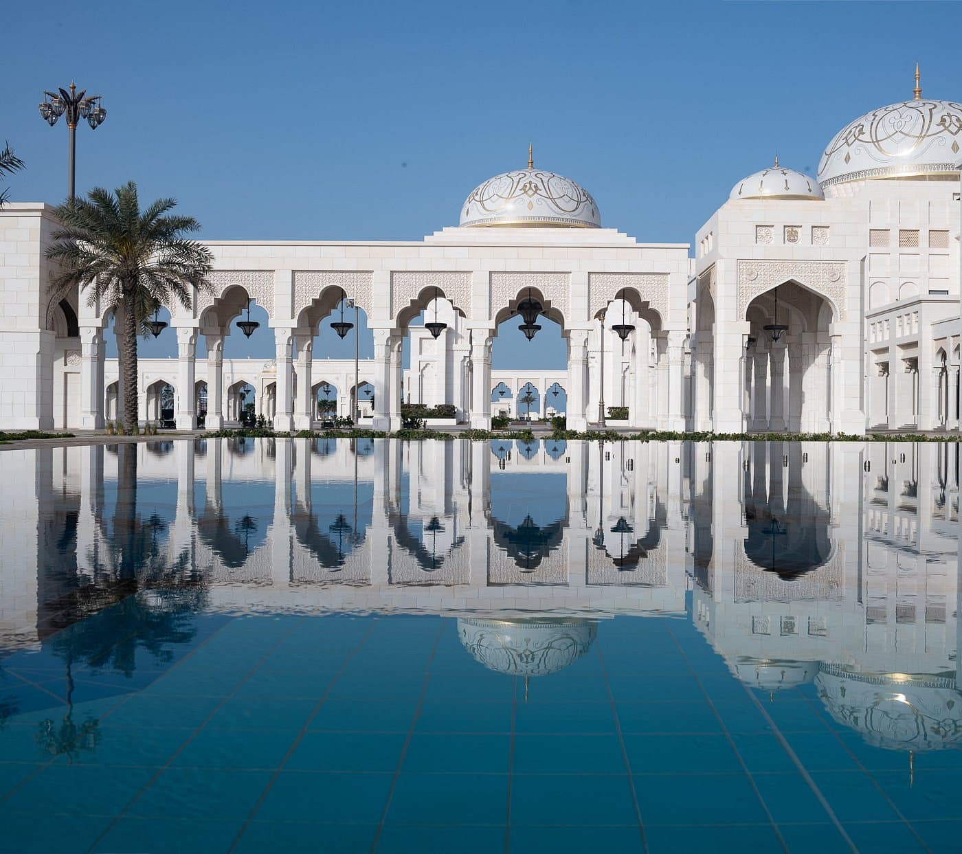 A side perspective of the Qasr Al Watan palace exterior, highlighting the repetitive architectural patterns of the domes and the grand scale of the Presidential Palace.