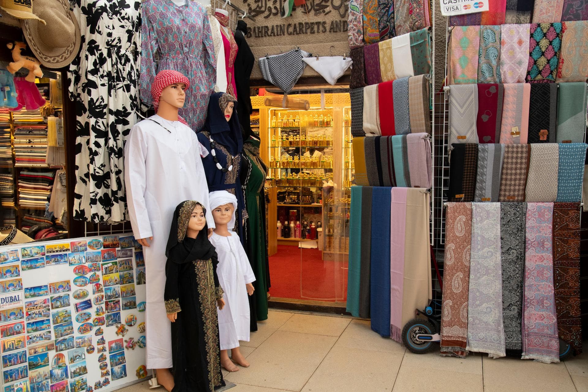 Traditional Arabic clothing mannequins and colourful scarves at Bahrain Carpets shop storefront in Al Fahidi Historical Neighbourhood Dubai