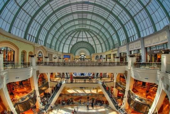 Spacious shopping galleries inside Mall of the Emirates Dubai, featuring luxury boutiques, escalators and an impressive glass dome.