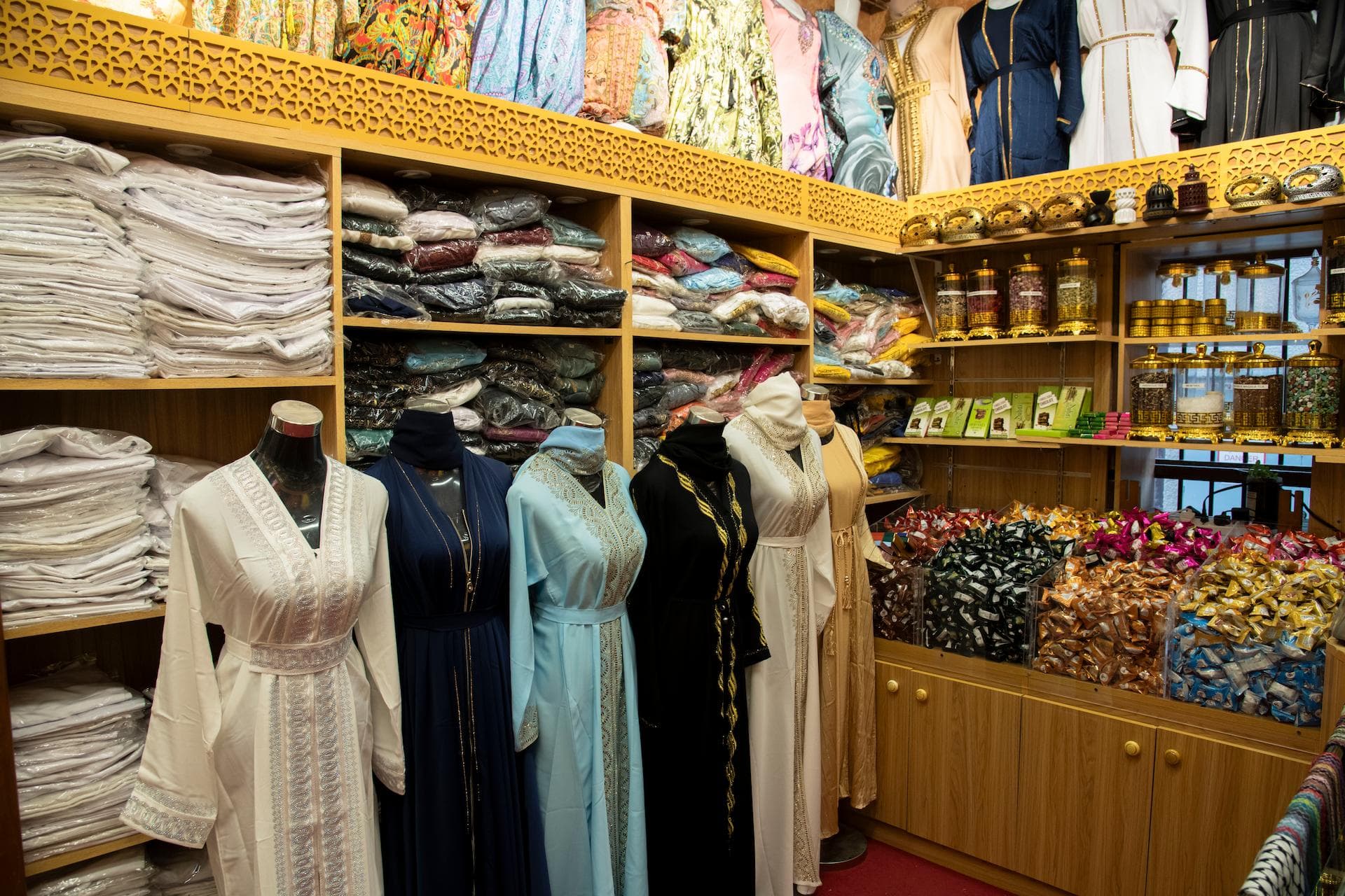 Traditional abaya and kaftan display with oud incense and Arabic sweets inside a shop at Al Fahidi Historical Neighbourhood Dubai
