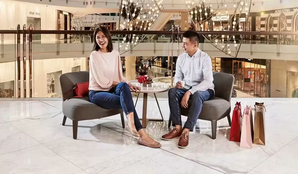 Couple relaxing with shopping bags in The Dubai Mall's Fashion Avenue seating area in Downtown Dubai