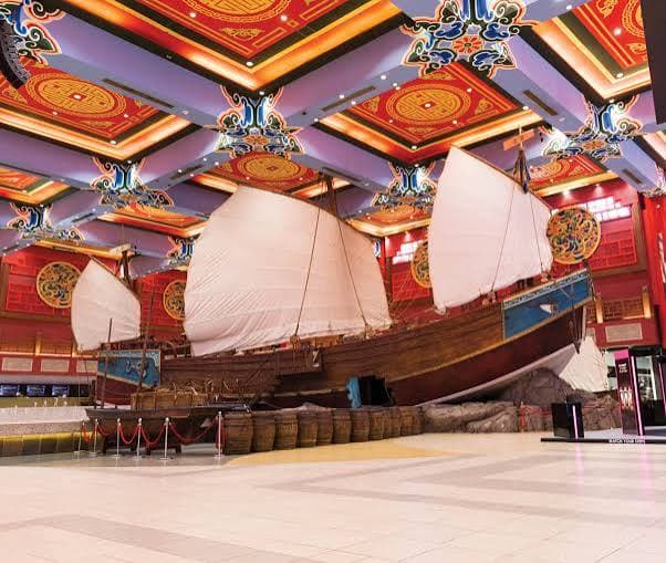 Traditional Chinese sailing ship displayed inside China Court at Ibn Battuta Mall Dubai, surrounded by colorful architectural decorations.